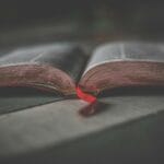 Biblia a Koran: co łączy święte księgi? Zbliżenie otwartej świętej księgi z czerwoną wstążką jako zakładką